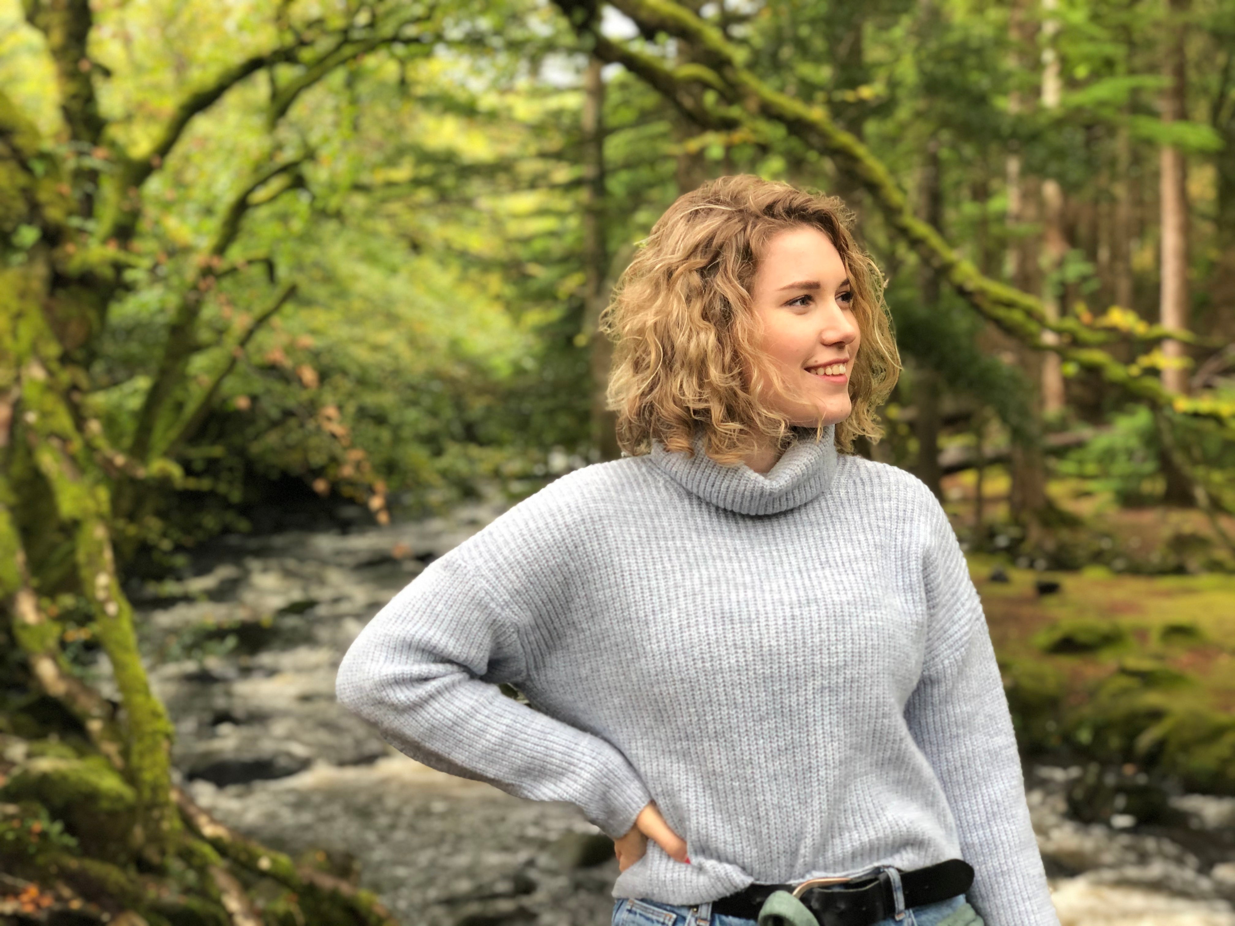 Teenage girl standing in a forest, promoting natural wellness and mindfulness through The Vitalogy Project.